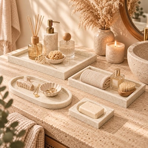 Peut inclure: Un ensemble d'accessoires de salle de bain en marbre beige comprenant des plateaux rectangulaires et ovales, un distributeur de savon, un porte-savon avec un savon, un petit bol, un flacon de parfum, un diffuseur et un gant de toilette.