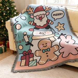 May include: A woven throw blanket featuring a light blue background with a cartoon Santa Claus, a snowman, a gingerbread man, and a pink rabbit. The design includes a speech bubble with the text MERRY, a star, a candle, and gift boxes.