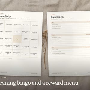 May include: Two white paper sheets featuring black text and grid layouts. The left sheet is titled Cleaning bingo with a five-by-five grid of tasks. The right sheet is titled Reward menu with sections for tiny, medium, and big rewards.