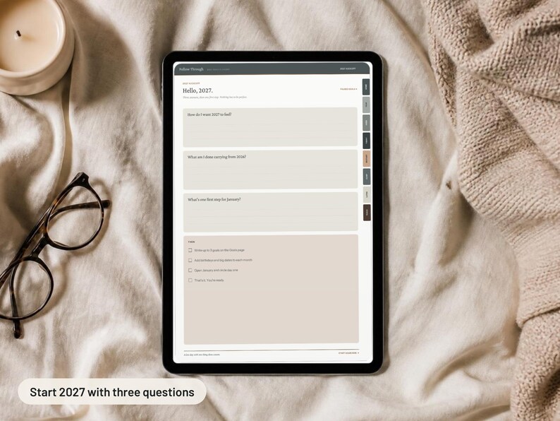 May include: A digital tablet displaying a 2027 planner page with the text Hello, 2027. The screen features three prompt boxes and a checklist section with checkboxes. The interface includes a dark gray header and a side navigation bar with tabs.