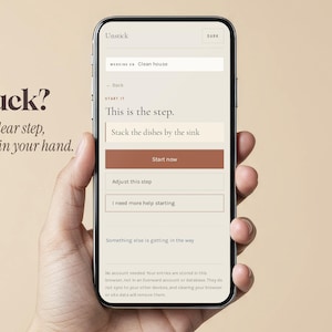 May include: A smartphone displaying the Unstick app interface with a light beige background. The screen shows the text 'Stuck? One clear step, right in your hand.' and 'This is the step. Stack the dishes by the sink' with a brown 'Start now' button.