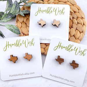 May include: Three cards with the text "Humble Wish" and a website address. Each card features a pair of wooden earrings shaped like the state of Texas. The earrings are in different shades of brown.