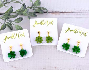 May include: Three pairs of green glitter shamrock earrings on white card stock with the text "Humble Wish" on each card.