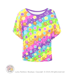 May include: A women's shirt in purple, yellow, green, blue and pink with a rainbow stripe pattern and a white star print. The stars have cute faces.