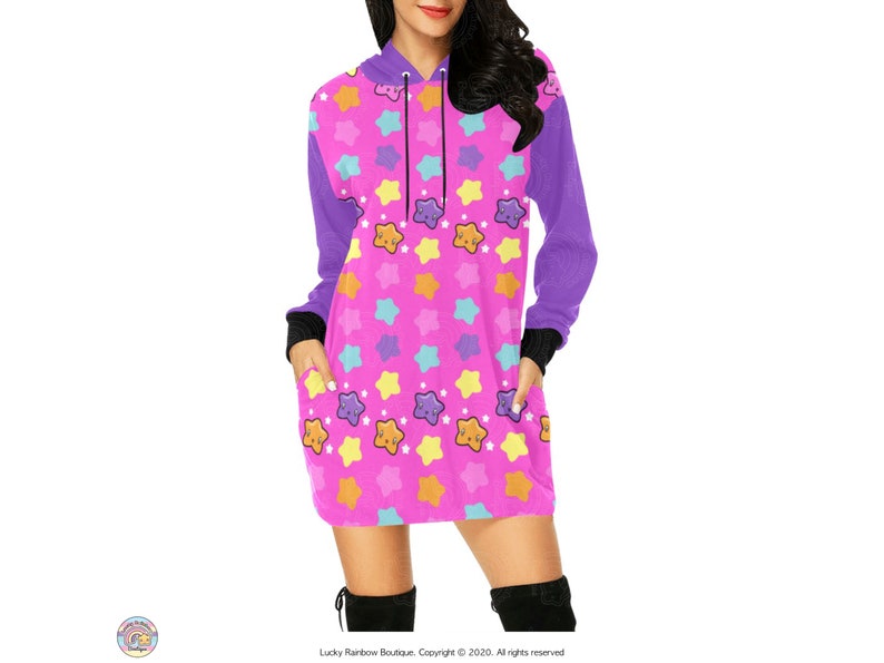 May include: A pink hooded dress with a purple sleeve and a pattern of colourful stars with smiling faces.