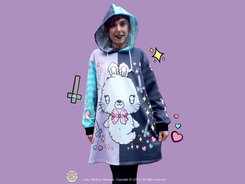 Ghost Bunny Hoodie Dress with Lilac and Grey Half and Half Background. Hearts and Crosses Motifs. Contrasting Turquoise and Grey Stripe sleeves with Corset Bow Print trailing down.