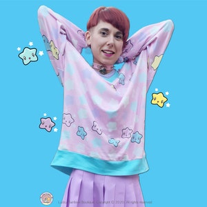 Kawaii All over Star Print Knit sweater on a Pastel Pink Background with contrasting V Neck, Sleeve Cuffs and Waist Band.