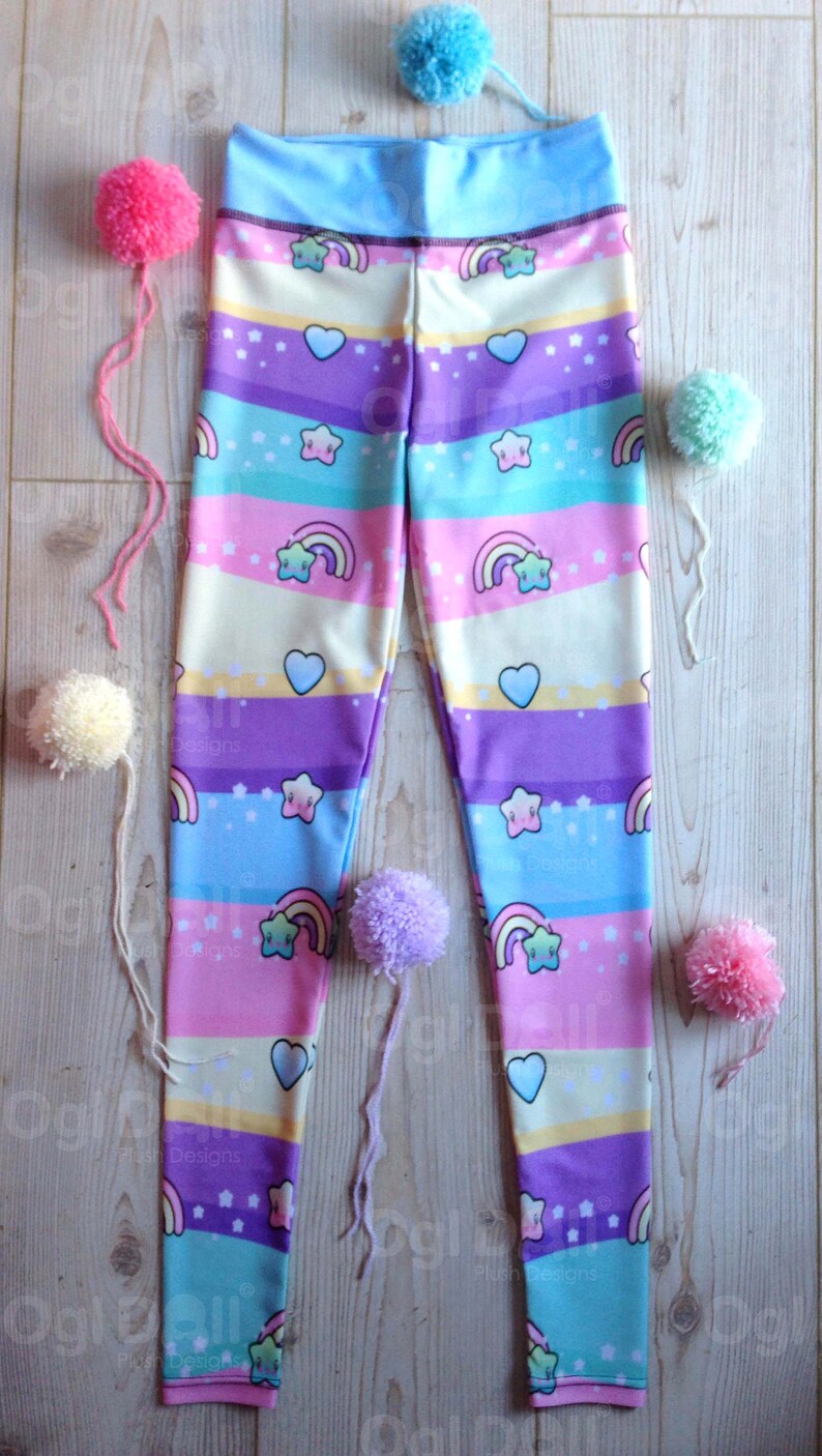 May include: A pair of colourful leggings with a rainbow, star and heart pattern. The leggings are made of a soft, stretchy fabric and are perfect for everyday wear.