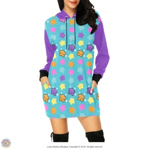 May include: A turquoise blue hooded dress with a purple sleeve and a pattern of colourful stars with smiling faces.