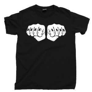 Op de afbeelding: Een zwart T-shirt met korte mouwen en een witte afbeelding van twee gebalde vuisten naast elkaar. Het woord NERD staat gedrukt op de knokkels van de linker vuist en het woord LIFE staat op de knokkels van de rechter vuist.