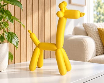 May include: A bright yellow sculpture shaped like a giraffe made from balloon-like segments. The figure features a long neck, a rounded head with small ears, and four legs, mimicking the appearance of a twisted balloon animal in a solid matte finish.