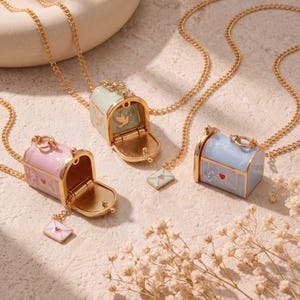 May include: Three gold-tone chain necklaces featuring miniature mailbox pendants in pastel pink, mint green, and light blue. Each mailbox has a hinged door, a small envelope charm, and decorative details including a heart and a dove.