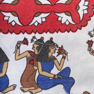 May include: A white fabric with a red and white patterned design. The fabric features an illustration of three women in colorful clothing holding flowers. The women are wearing headbands and have dark hair.
