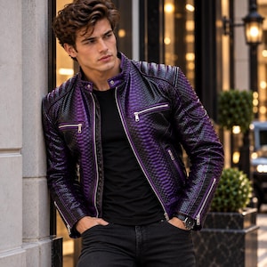 Peut inclure: Une veste à texture peau de serpent violette et noire avec un col montant, des fermetures éclair en métal argenté sur le devant et les poignets, et un t-shirt noir porté en dessous. La veste présente une coupe structurée avec des manches longues.
