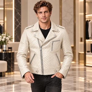 May include: A cream-colored motorcycle jacket featuring a textured snakeskin-like pattern, a wide notched collar, silver-tone metal zippers on the front and cuffs, two slanted side pockets, and a single chest pocket with a zipper closure.