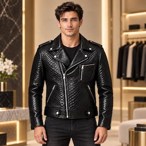 Peut inclure: Une veste de moto noire avec un motif texturé rappelant la peau de serpent, des fermetures éclair en métal argenté sur le devant et les poches, un large col cranté, des épaulettes et une ceinture à boutons-pression argentés sur un t-shirt noir.