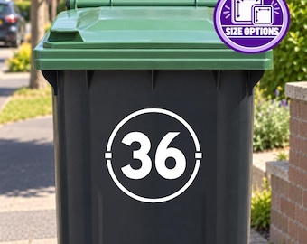 Op de afbeelding: Een donkergrijze buitenafvalbak met een witte cirkelvormige sticker met het nummer 36 in het midden. De bak heeft een groen deksel en een paarse ronde badge in de rechterbovenhoek met twee witte vierkante iconen en de tekst SIZE OPTIONS.