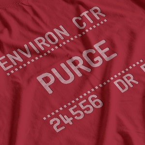 Pode incluir: Uma camiseta vermelha com texto branco. O texto inclui "ENVIRON CTR", "PURGE", "24556" e "DR 5". O texto está disposto diagonalmente na camiseta.