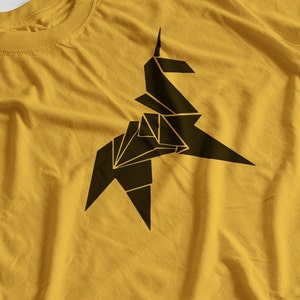 Peut inclure: Un t-shirt jaune avec un motif d'unicorn en origami noir.