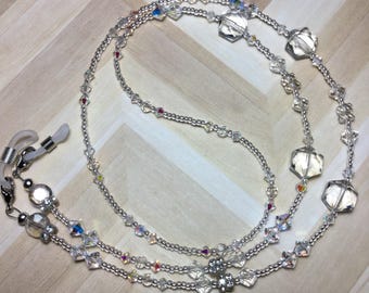 May include: A silver chain with clear crystal beads and larger hexagonal beads. The chain has two loops at each end for attaching to glasses.