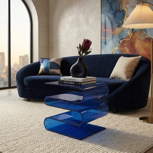 May include: A translucent blue acrylic side table with a continuous S-shaped design. The table features a smooth, curved structure with multiple horizontal surfaces, providing a clear view through the material to the floor beneath the furniture.