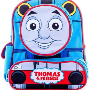 May include: Blue and red Thomas the Tank Engine backpack with a large front pocket featuring Thomas's face. The backpack has a smaller front pocket with the words "Thomas & Friends" printed on it.
