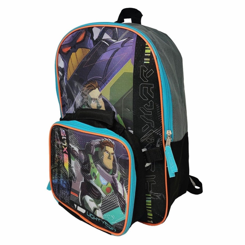 Puede incluir: Una mochila negra con ribetes azules y naranjas. La mochila tiene una bolsa de almuerzo unida al frente. La bolsa de almuerzo tiene una imagen de un personaje de dibujos animados. La mochila tiene una cremallera en el lateral y una cremallera en la parte superior. La mochila tiene un asa en la parte superior y correas en los laterales.