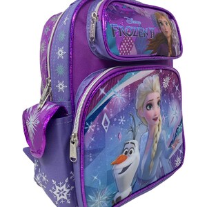 May include: Purple Frozen II backpack with a front pocket featuring Elsa and Olaf. The main compartment has a large image of Elsa and Olaf with a sparkly blue and purple background. The backpack has a side pocket with a snowflake design.