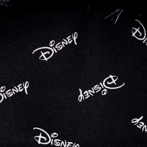 May include: Black fabric with a white repeating pattern of the Disney logo.