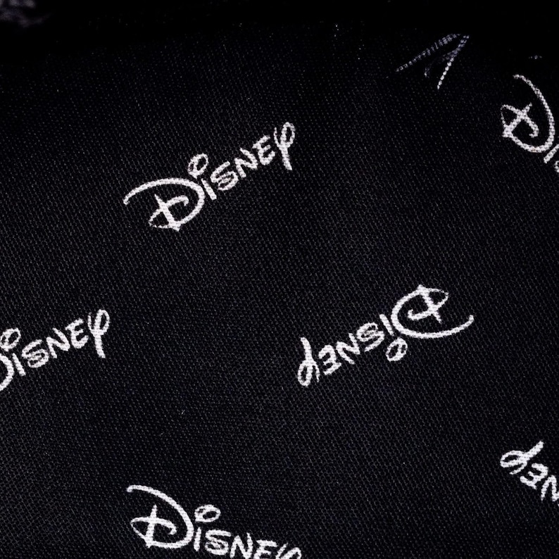 May include: Black fabric with a white repeating pattern of the Disney logo.