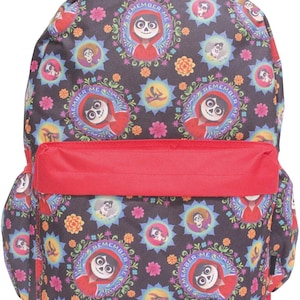 May include: Black backpack with a colourful pattern of flowers and characters from the film "Coco". The pattern includes the phrase "Remember Me" in a circle around the main character. The backpack has a red zipped pocket on the front.