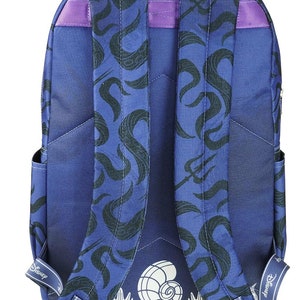 May include: A blue backpack with a black and white print of waves and a seashell. The backpack has purple straps and a white "Disney" logo on the straps.