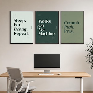 May include: Three framed wall art prints featuring dark green typography on light green, dark green, and sage green backgrounds. The text reads Sleep. Eat. Debug. Repeat., Works On My Machine., and Commit. Push. Pray. with small grid patterns.