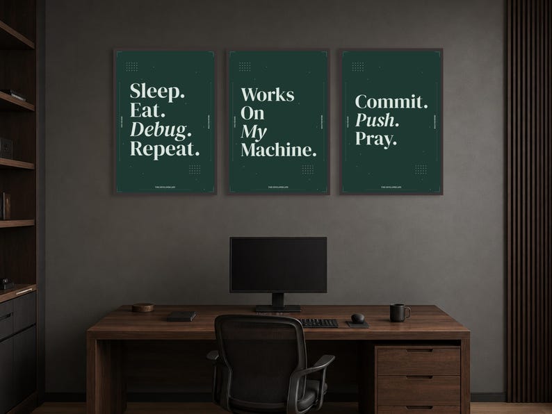 May include: Three dark green rectangular wall posters with white text. The first reads Sleep. Eat. Debug. Repeat. The second reads Works On My Machine. The third reads Commit. Push. Pray. Each poster features small geometric grid patterns in the corners.