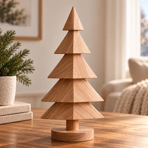 Peut inclure: Une sculpture d'arbre décorative en bois présentant un design empilé avec quatre niveaux triangulaires distincts et un sommet pointu. L'objet est fabriqué en bois clair avec un grain visible, soutenu par une tige cylindrique et une base circulaire.