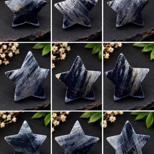 May include: A collection of nine star-shaped polished stones featuring a dark blue and grey marbled pattern with subtle white and gold flecks. Each stone has a smooth, glossy surface and distinct natural veining throughout the star shape.