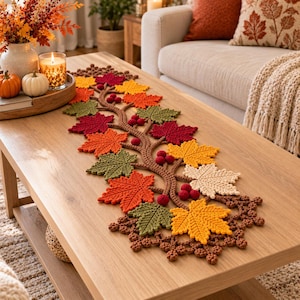 May include: A crochet table runner featuring a central brown vine design adorned with various autumn-coloured leaves in shades of red, orange, yellow, green, and cream, accented with small dark red berries and a textured brown border.