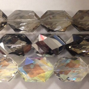 Peut inclure: Trois rang&eacute;es de perles en verre facett&eacute;es. La rang&eacute;e du haut est transparente avec une teinte fum&eacute;e. La rang&eacute;e du milieu est gris fonc&eacute; avec une finition miroir. La rang&eacute;e du bas est transparente avec une finition iris&eacute;e.