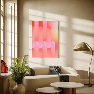 May include: A rectangular wall art print featuring a vertical pattern of overlapping rounded pill shapes in gradient shades of pink, coral, and orange, displayed in a thin light-colored frame against a neutral-toned interior wall.