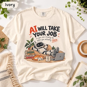 Op de afbeelding: Een ivoorkleurig t-shirt met een afbeelding van een robot die ontspant op een zitzak met een laptop, een slapende oranje kat, een stapel boeken met de tekst Travel, Good Food, Hobbies, More Sleep, Happiness en een mok met Life Mode On.