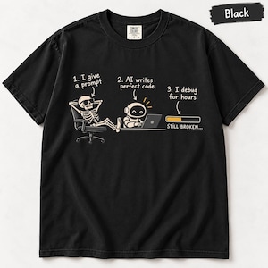 May include: A black t-shirt featuring a graphic with a skeleton in sunglasses sitting in a chair, a small robot typing on a laptop, and a loading bar. The text reads: 1. I give a prompt, 2. AI writes perfect code, 3. I debug for hours, STILL BROKEN...