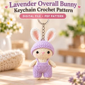 May include: A crochet bunny keychain wearing lavender overalls and a matching hat. The text reads Lavender Overall Bunny Keychain Crochet Pattern and Digital File PDF Pattern. The bunny has cream-colored fur, pink inner ears, and black eyes.