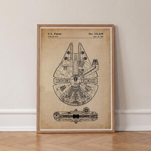 Puede incluir: Una impresión enmarcada con un dibujo de líneas negras de una nave espacial sobre un fondo beige. El texto dice U.S. Patent, Des 232,838, Lucas, Jr. et al. y June 15, 1981. La obra muestra una vista superior y lateral del diseño de la nave.