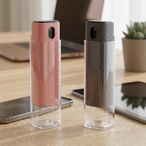 May include: Two rectangular screen cleaning spray bottles, one in dusty pink and one in dark gray. Each bottle features a clear base and a textured, colored outer shell with a built-in spray nozzle at the top for cleaning electronic displays.