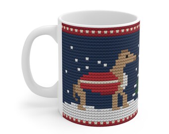 May include: A white ceramic mug featuring a dark blue knit-patterned design. The graphic depicts a tan dinosaur wearing a red sweater standing in white snow with falling white snowflakes and a small green pine tree to the right side.