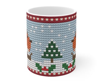 May include: A ceramic mug featuring a printed pattern that mimics a knitted sweater texture. The design displays a light blue background with white snowflakes, a central green pine tree, orange birds, and red and white border stripes.