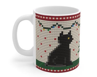 May include: A white ceramic mug featuring a printed pattern of a black cat sitting on a green surface against a beige background. The design includes red and white borders, small red squares, and a string of colorful Christmas lights.