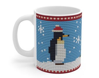 May include: A white ceramic mug featuring a blue background with a repeating knit-style pattern. The design displays a penguin wearing a red and white hat, surrounded by white snowflakes, with red and white striped borders at the top and bottom.