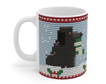 May include: A white ceramic mug featuring a printed pattern of a black dog wearing a green and white striped scarf. The design mimics a knitted texture with a light blue background, white snowflakes, and a red and white border at the top and bottom.