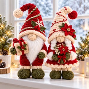 May include: Two crocheted gnome figurines. The left gnome wears a red hat with a white snowflake and holds a beige gift box. The right gnome wears a cream hat with a red poinsettia and holds a bouquet of red flowers and white berries.